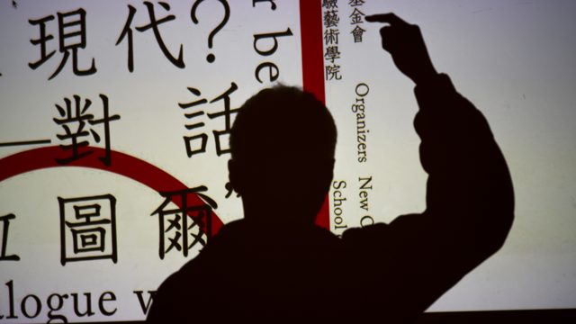 人物剪影举手，后方投影可见中英文字
