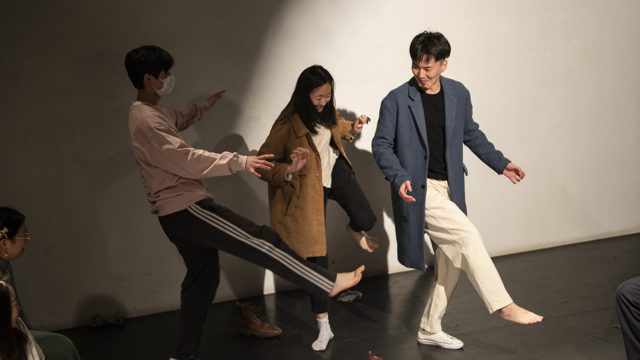 三人站立，腿部抬起或向外伸出