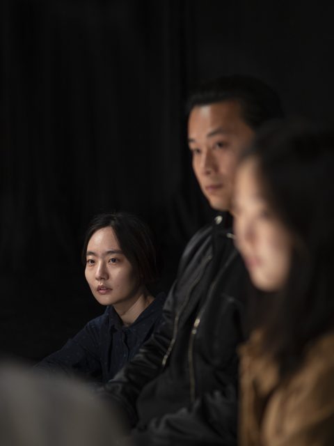 近景人物身体与后方坐姿人物