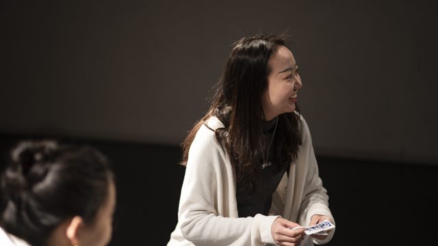 一人坐姿手持小张纸卡
