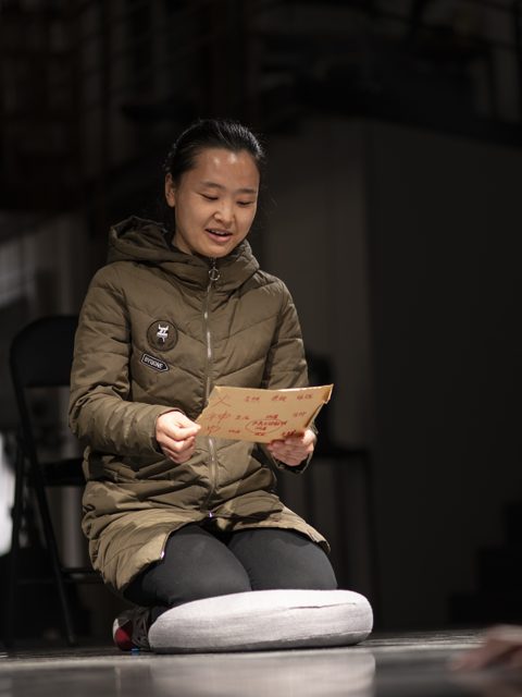 一人坐着持纸观看