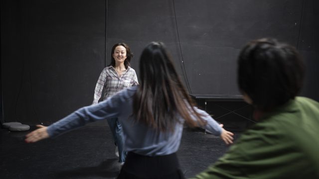 两人张臂，第三人位于后方